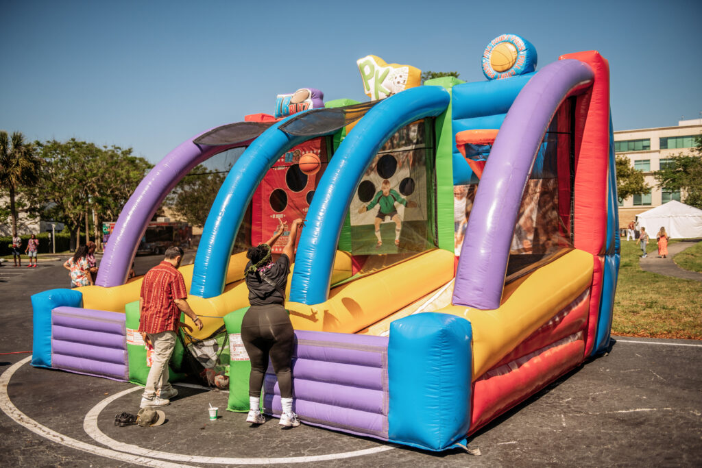 Inflatable carnival toss game entertaining kids at an outdoor luau event in Orlando