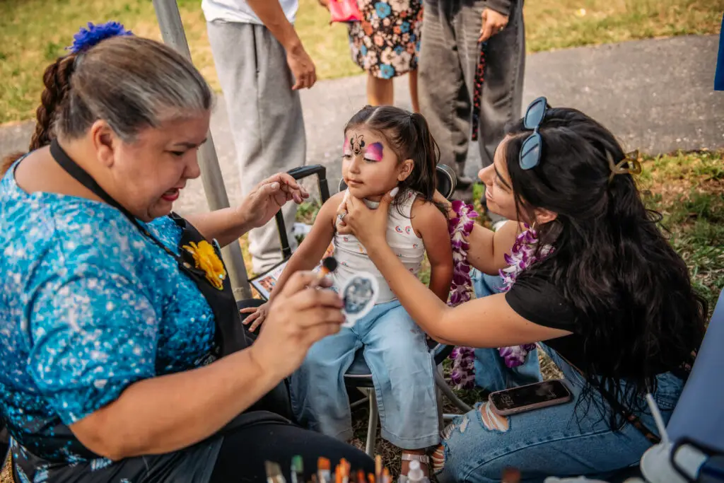 Tribal face painting station at a Hawaiian-themed corporate event