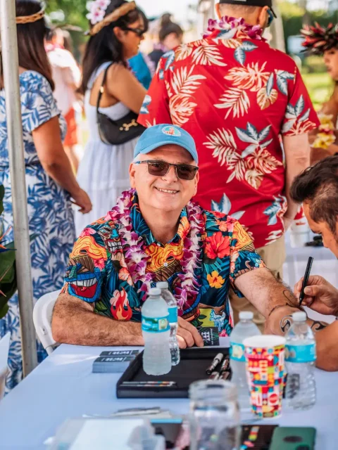 Guests at a Hawaiian name writing activity station during a luau event