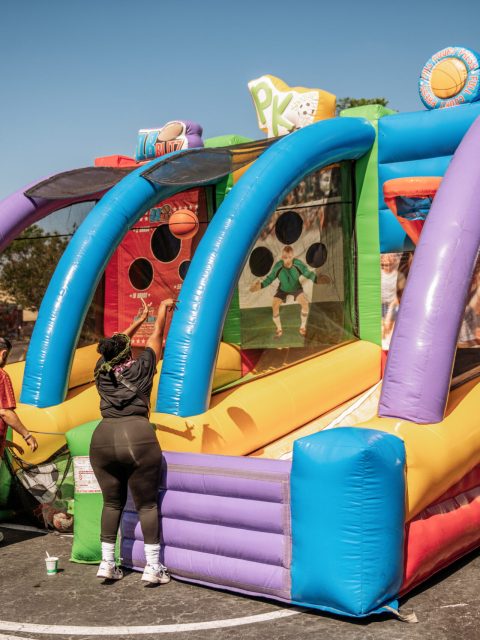 Inflatable carnival toss game entertaining kids at an outdoor luau event in Orlando