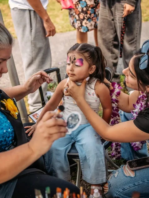 Tribal face painting station at a Hawaiian-themed corporate event